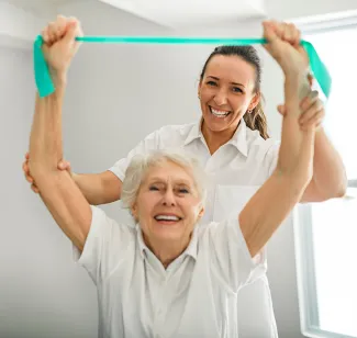 Mitarbeiterin bei PFLEGEN & WOHNEN HAMBURG macht Ergotherapie mit Bewohnerin für ihre mentale und körperliche Gesundheit.