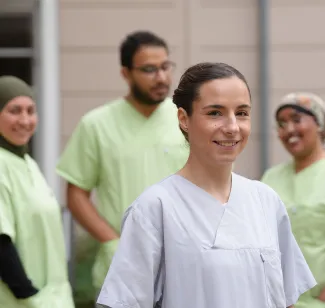 Auszubildende Pflegefachkraft bei PFLEGEN & WOHNEN HAMBURG mit unterstützenden Kollegen.