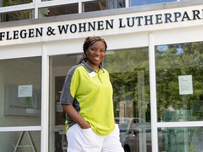 Kossia Edwige Neugart bei PFLEGEN & WOHNEN LUTHERPARK vor dem Eingangsbereich im ruhigen Stadtteil.